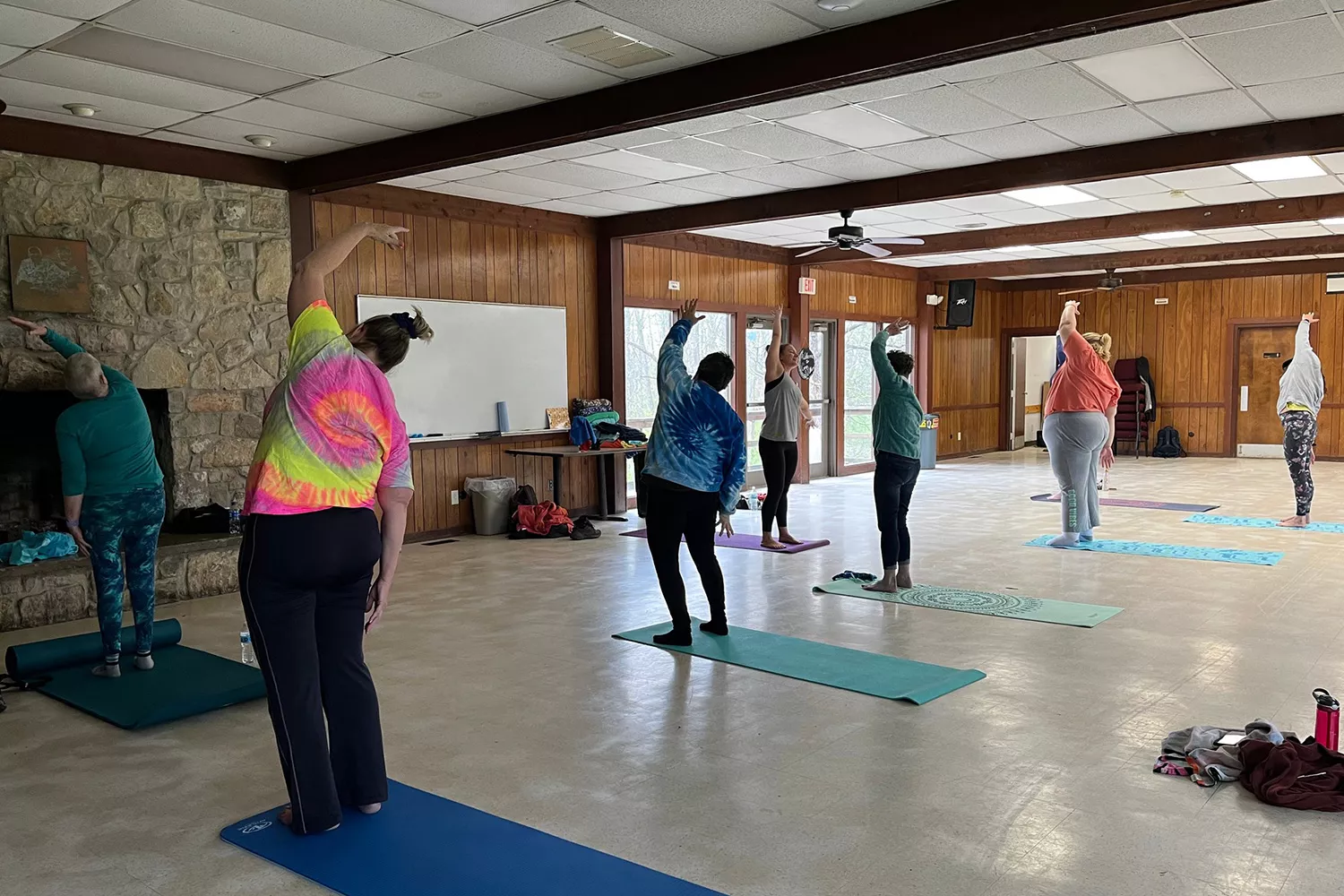 Adult campers doing yoga indoors at camp