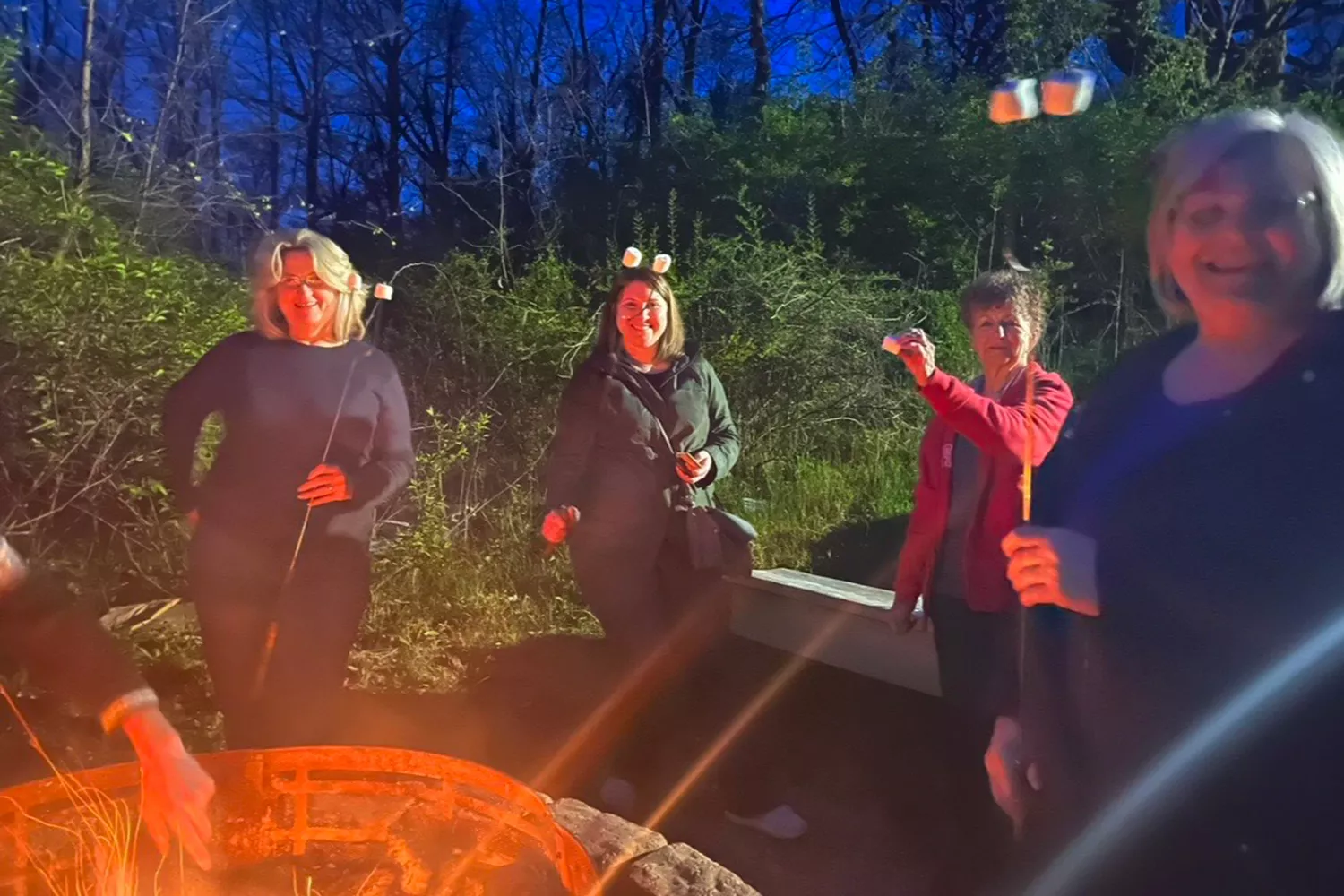 women's weekend campers roasting marshmallows